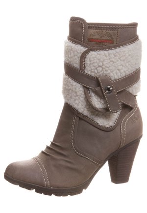 Brązowe botki na kostkę z sztucznym futrem przy mankiecie, detal z klamrą i stębnowane akcenty. Posiadają teksturowany obcas i zaokrąglony czubek.