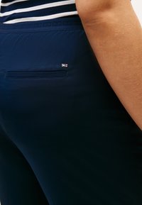 Παντελόνια σε ναυτικό μπλε χρώμα από απαλό ύφασμα με πίσω τσέπη και μικρή λογότυπο λεπτομέρεια. Η ζώνη έχει υφασμάτινο σχέδιο.