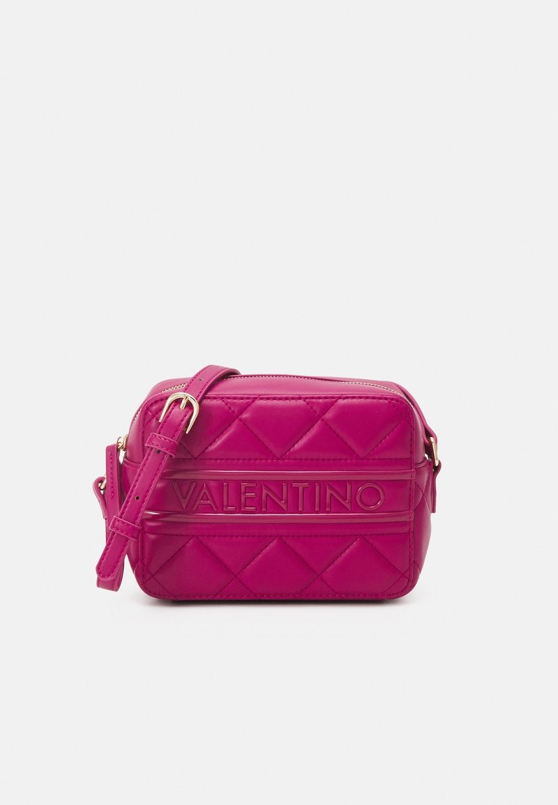 Quilted pink leather crossbody bag with a zipper closure and adjustable strap. Features embossed brand name on a smooth band.