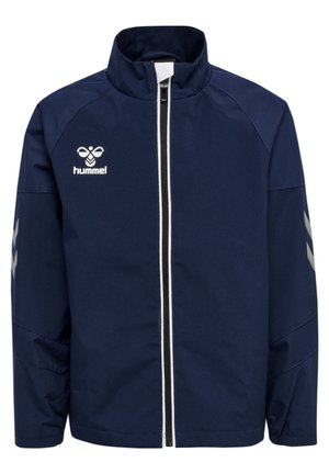 Marineblaue Zip-up-Jacke mit hohem Kragen, weißem Reißverschlussbesatz, Hummel-Logo auf der Brust und reflektierenden Chevron-Streifen an den Ärmeln.