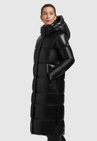 Schwarzer, glänzender Puffermantel mit Kapuze, im langen Design, horizontal gesteppten Paneelen und seitlichen Taschen. Mit einem Markenlogo akzentuiert.