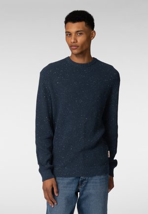 Mørkeblå ribbestrikket genser med spraglete detaljer, rund hals og lange ermer. Stoffet har en teksturert følelse; har en liten merkelapp nederst.