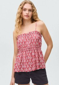 Red patterned top with spaghetti straps, gathered neckline, and smocked waist. Features a paisley design in white with a flared shape.