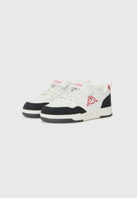 Hvite og svarte lave sneakers med rødt logo, perforerte sider, borrelåsremmer og snøring, vist mot en lys grå bakgrunn.
