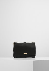 Borsa a tracolla nera in ecopelle con una texture liscia, forma rettangolare, hardware in tonalità oro e una piccola placca con logo sul davanti.