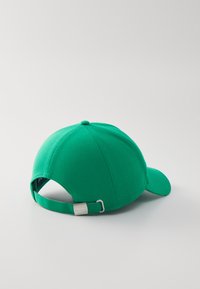 Boné de basebol verde com uma aba curva, tecido de algodão macio, faixa ajustável com fecho de metal e uma pequena etiqueta da marca na parte de trás.