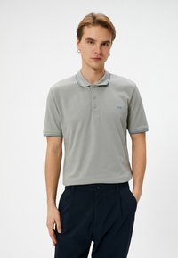 Grå kortærmet polo skjorte med en tre-knaps placket, kontrasterende lyseblå krave og ærmekanter samt subtil broderi på brystet.