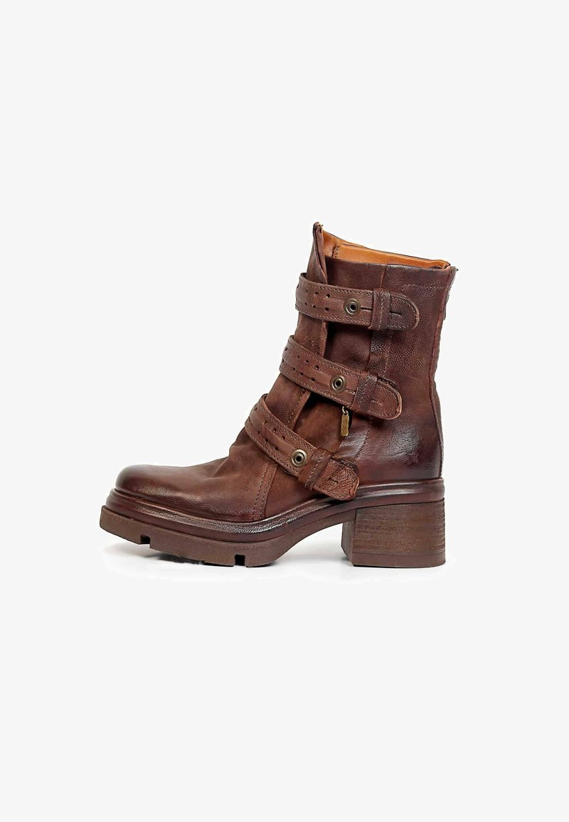 Bottine en cuir marron avec trois brides ajustables, bout rond, talon épais superposé et semelle en caoutchouc texturée.