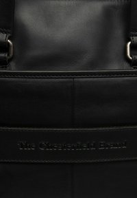 Borsa in pelle nera con una superficie liscia. Presenta un marchio impresso sul davanti e cuciture rinforzate lungo le giunture.