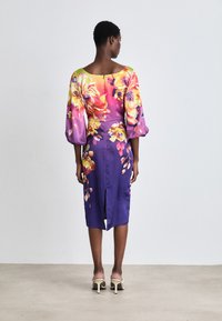 Satinblumenkleid in gradientem Rosa und Lila, mit Puffärmeln, einem Schlitz auf der Rückseite und einer taillierten Silhouette mit mehrfarbigen Blumenmustern.