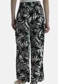 Zwart-wit geruite wijde broek met elastische tailleband, voorzien van een tropisch bladmotief en gemaakt van lichtgewicht stof.