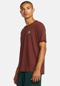 Bordeaux crew neck t-shirt met korte mouwen, voorzien van een klein grafisch logo in een vierkant nabij de borst, gemaakt van zachte stof.