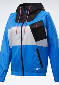 Veste à capuche bleue, blanche et noire avec des cordons de serrage roses, une poche poitrine noire diagonale avec un bouton rose, une fermeture éclair à l'avant et des poches latérales.