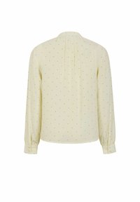 Blusa crema con maniche lunghe, caratterizzata da pois neri, un retro plissettato e polsini bottinati. Tessuto liscio con una vestibilità rilassata.