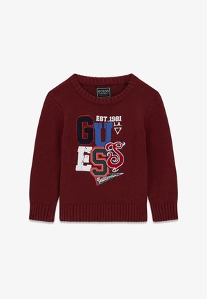 Pull en maille grenat avec logo GUESS en lettres rouges, blanches et bleues mélangées, inscriptions "EST. 1981," "L.A.," et "California" imprimées sur l'avant.