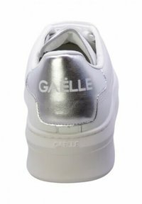 Sneaker bianca con tacco metallico argentato, caratterizzata dal logo "GAËLLE". Texture liscia con punta arrotondata e suola spessa e imbottita.