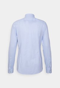 Chemise à manches longues à rayures verticales bleu clair et blanc avec poignets boutonnés, vue de dos sur un fond uni.