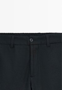 Pantalon noir avec une texture lisse, doté d'une taille, d'une fermeture à bouton et de passants de ceinture. Coupé avec un design à jambe droite.