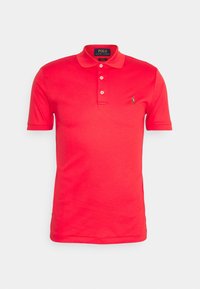 Rotes Poloshirt aus Baumwolle, mit Kragen, kurzen Ärmeln, einer Drei-Knopf-Leiste und einem kleinen grünen gestickten Logo auf der Brust.
