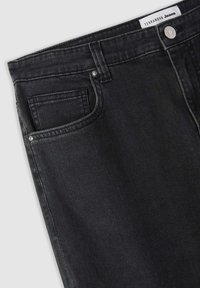 Czarne dżinsy o gładkiej fakturze, z klasycznym pięciopocketowym wzornictwem, metalowymi guzikami oraz kontrastowymi szwami.