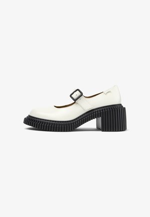 White platform Mary Jane shoe with a textured black rubber heel and a buckle strap, featuring a rounded toe and smooth leather upper.