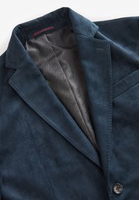 Dunkelblauer Wildleder-Blazer mit Reverskragen, sichtbarem gemustertem Innenfutter, Brusttasche und Ein-Knopf-Verschluss.