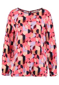 Blouse à manches longues avec un col rond, présentant un motif géométrique audacieux aux tons rose, violet, beige et noir.