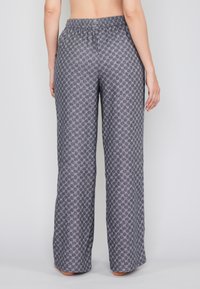 Grau gemusterte Hose in lockerer Passform, mit elastischem Bund und geometrischem Design. Leichter Stoff sorgt für Textur.