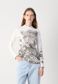 Witte longsleeve top met een zwart en grijs luipaardprint, voorzien van een scalloped halslijn en subtiele textuur.