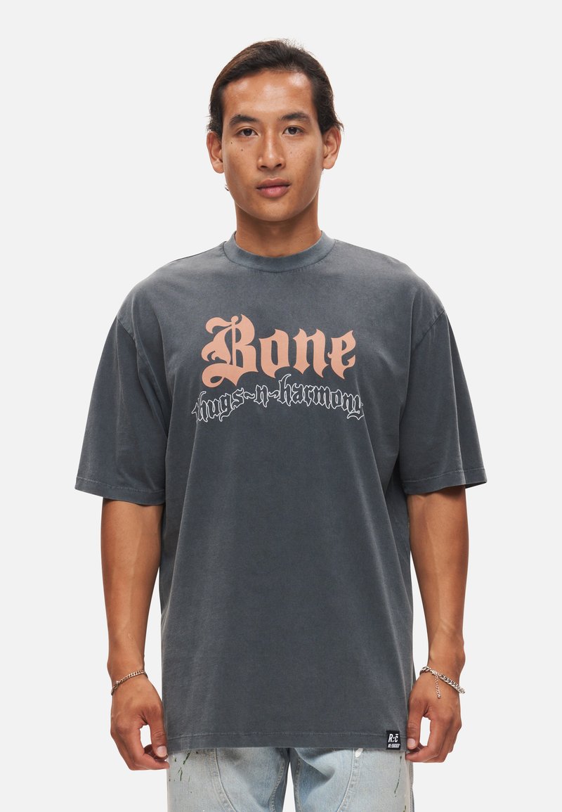 Grå oversized T-shirt lavet af bomuld, med stor pink og sort grafisk tekst "Bone thugs-n-harmony" på forsiden.