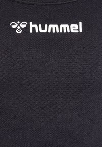 Zwarte Hummel sporttop met een getextureerde stof, ronde halslijn en een opvallend wit logo met bij-embleem op de borst.