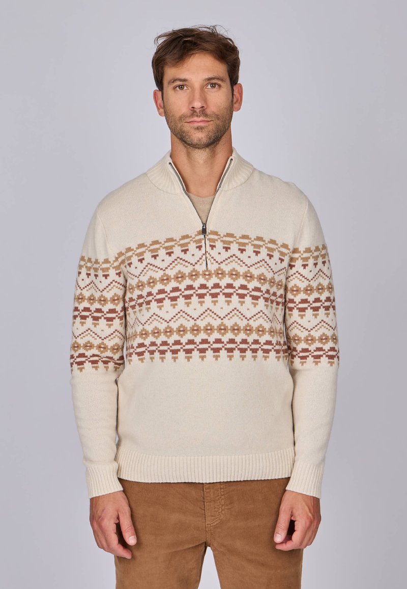 Pull en tricot crème avec un col à zip demi. Présente un motif géométrique dans des tons terreux (marrons, beige) sur la poitrine. Manches et ourlet côtelés.