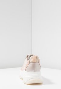 Tenisky v kombinaci světle růžové a béžové semišové kůže a síťoviny, s texturovanou bílou podrážkou a malým béžovým poutkem na patě.