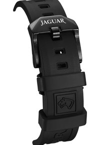 Correa de reloj de goma negra con acabado mate, que presenta una hebilla de metal grabada con "JAGUAR" y un logo de cabeza de león en el sujetador.