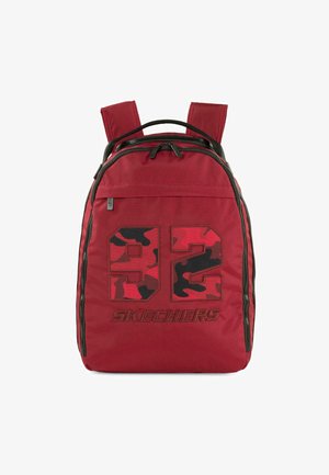 Mochila de tela roja con un gran gráfico de camuflaje negro y rojo "92" y la marca "SKECHERS", con dos correas ajustables y un bolsillo con cremallera.