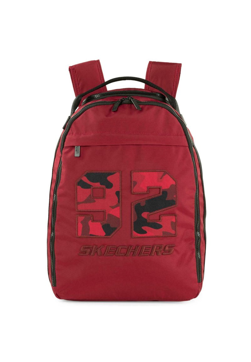 Mochila de tela roja con un gran gráfico de camuflaje negro y rojo "92" y la marca "SKECHERS", con dos correas ajustables y un bolsillo con cremallera.