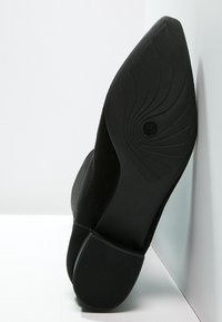 Zwarte suède enkellaarsjes met een puntige neus en een gestructureerde rubberen zool. Vormgegeven hak met een spiraalontwerp voor extra grip en stabiliteit.