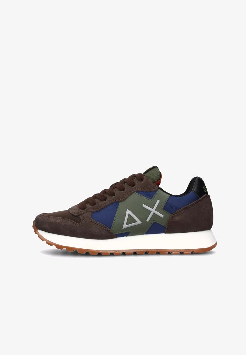 Sneaker in suede marrone e mesh con accenti verdi e blu. Presenta una intersuola bianca, un tab sul tallone nero e un logo geometrico sul lato.