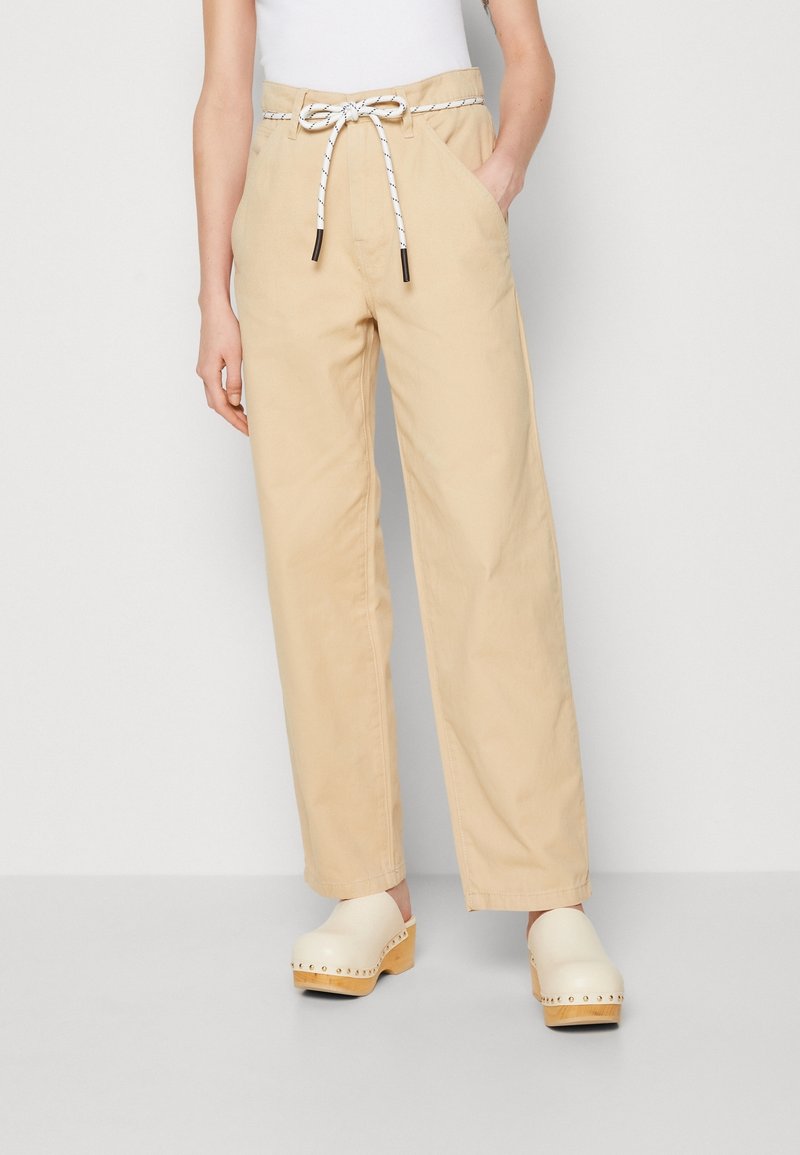 Beige široké kalhoty z bavlny, s páskem na šňůrku s černo-bílým provázkem a dvěma bočními kapsami.