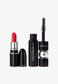 Rode lippenstift in een zwarte huls, een zwarte mascara-tube met een zilveren accent, en een cilindrische zwarte stapelcontainer, allemaal van MAC.