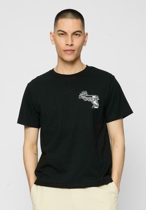 T-shirt en coton noir avec un motif blanc représentant un pistolet entrelacé avec une rose sur la poitrine gauche, design classique à col rond.