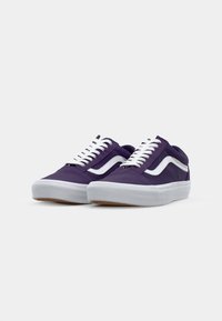 Purple canvas sneakers with white accents and laces, featuring a low-profile design and rubber outsole, displayed from a slight angle.