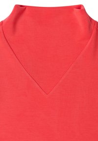 Korálowy top z wysokim, składanym kołnierzem i głębokim dekoltem w kształcie litery V. Wykonany z gładkiej tkaniny, w jednolitym kolorze, bez widocznych wzorów ani zdobień.