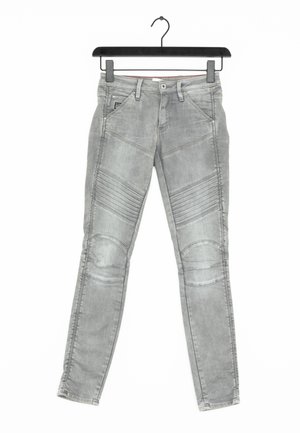 Jeans skinny gris avec des accents texturés au niveau des genoux, des détails de couture et un design classique à cinq poches. Fabriqués en denim.