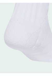 Calcetín de algodón blanco con textura acanalada, acabado suave y talón reforzado. El diseño garantiza comodidad y un ajuste ceñido.