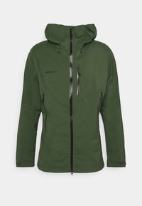 Zielona wodoodporna kurtka z kapturem, z czarnymi zamkami błyskawicznymi, wysokim kołnierzem i przeszyciami dekoracyjnymi. Widoczna nazwa marki "Mammut".