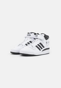 Høje sneakers i hvid læder med sorte striber. Har polstret ankelstøtte, en remlukning og en struktureret gummisål.