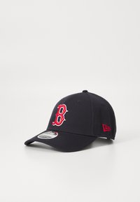 Gorra de béisbol azul marino con un logo bordado en rojo que dice "B". Cuenta con un visera curva y un diseño ajustado. Fabricada con un material duradero. Marca New Era en el lado.