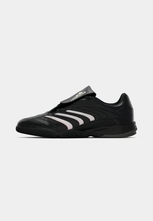 Schwarzer Sportschuh mit einem schlanken Design, synthetischem Obermaterial, weißen gestreiften Akzenten, niedrigem Schnitt und einem Klettverschluss über dem Fußrücken für einen sicheren Sitz.