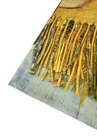 Tessuto frangiato con fili gialli e dorati di diverse trame; sullo sfondo si vede un tessuto blu chiaro con motivi sottili.